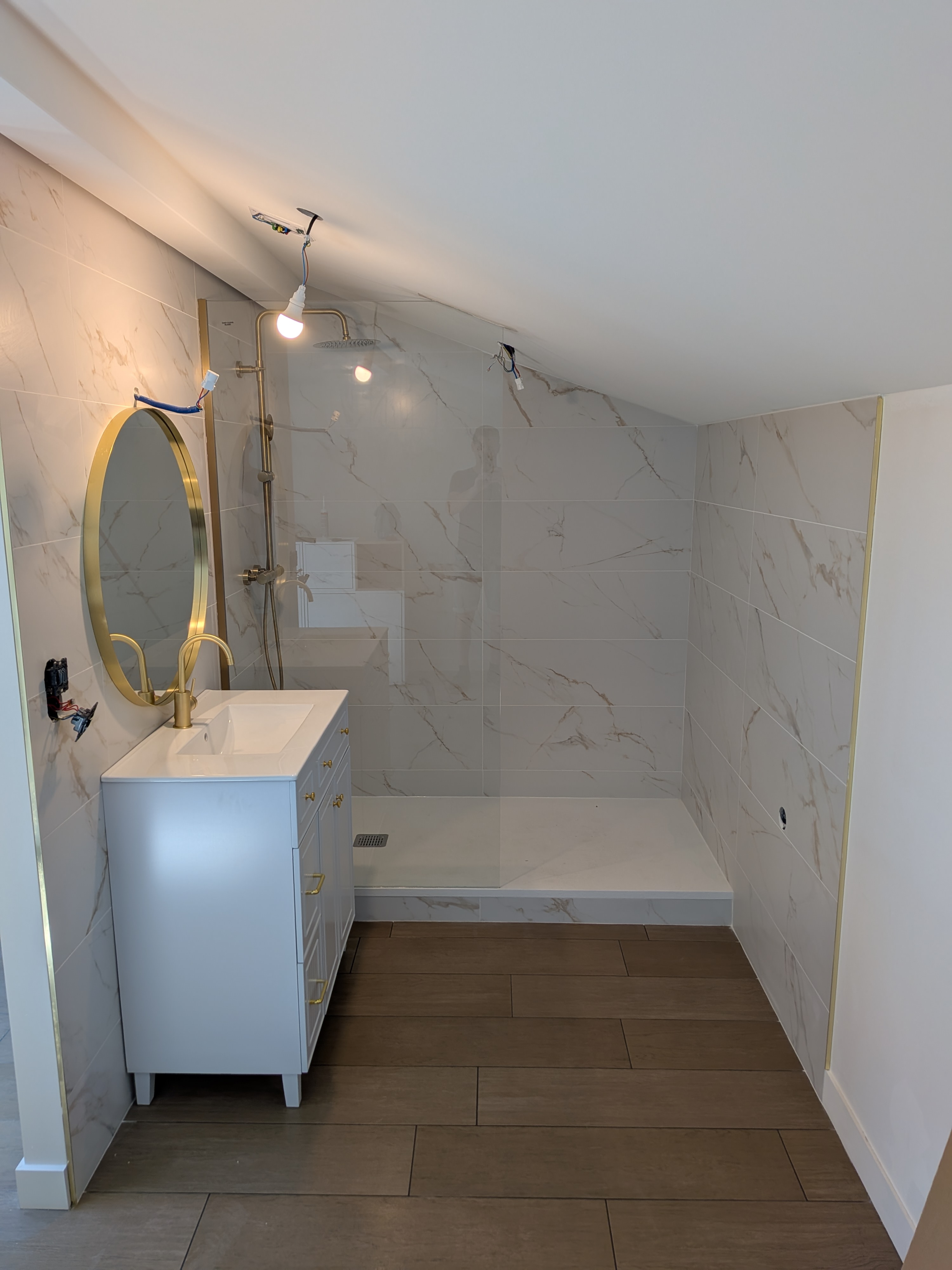 Salle de bain rénovée avec douche à l'italienne et finitions dorées
