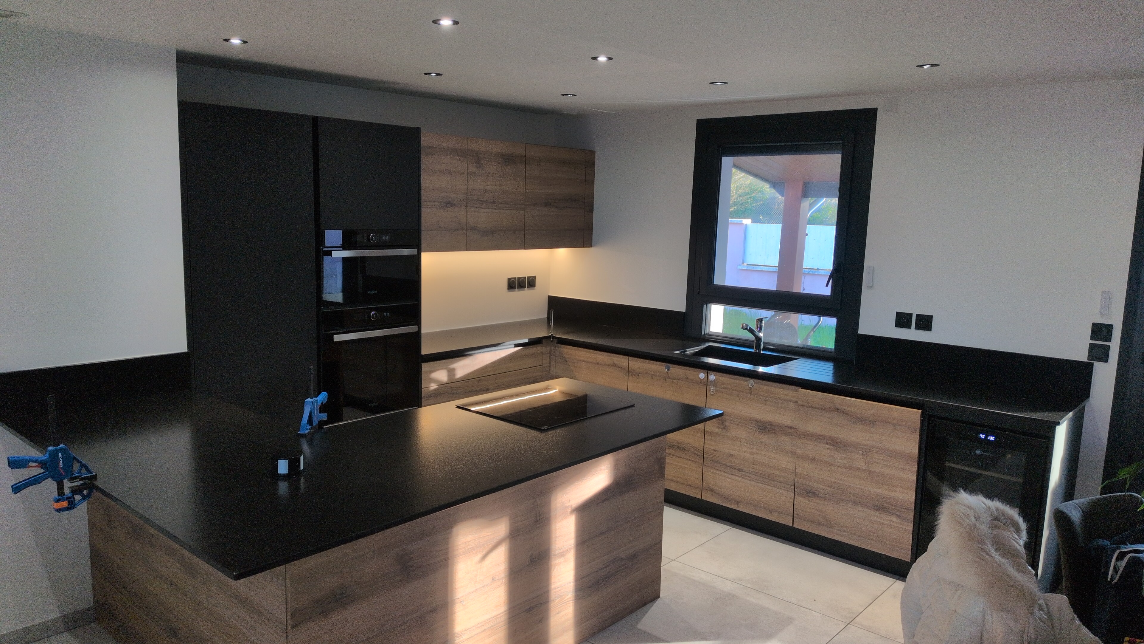 Cuisine rénovée avec plan de travail noir, dans un logement chauffé par VilaNova