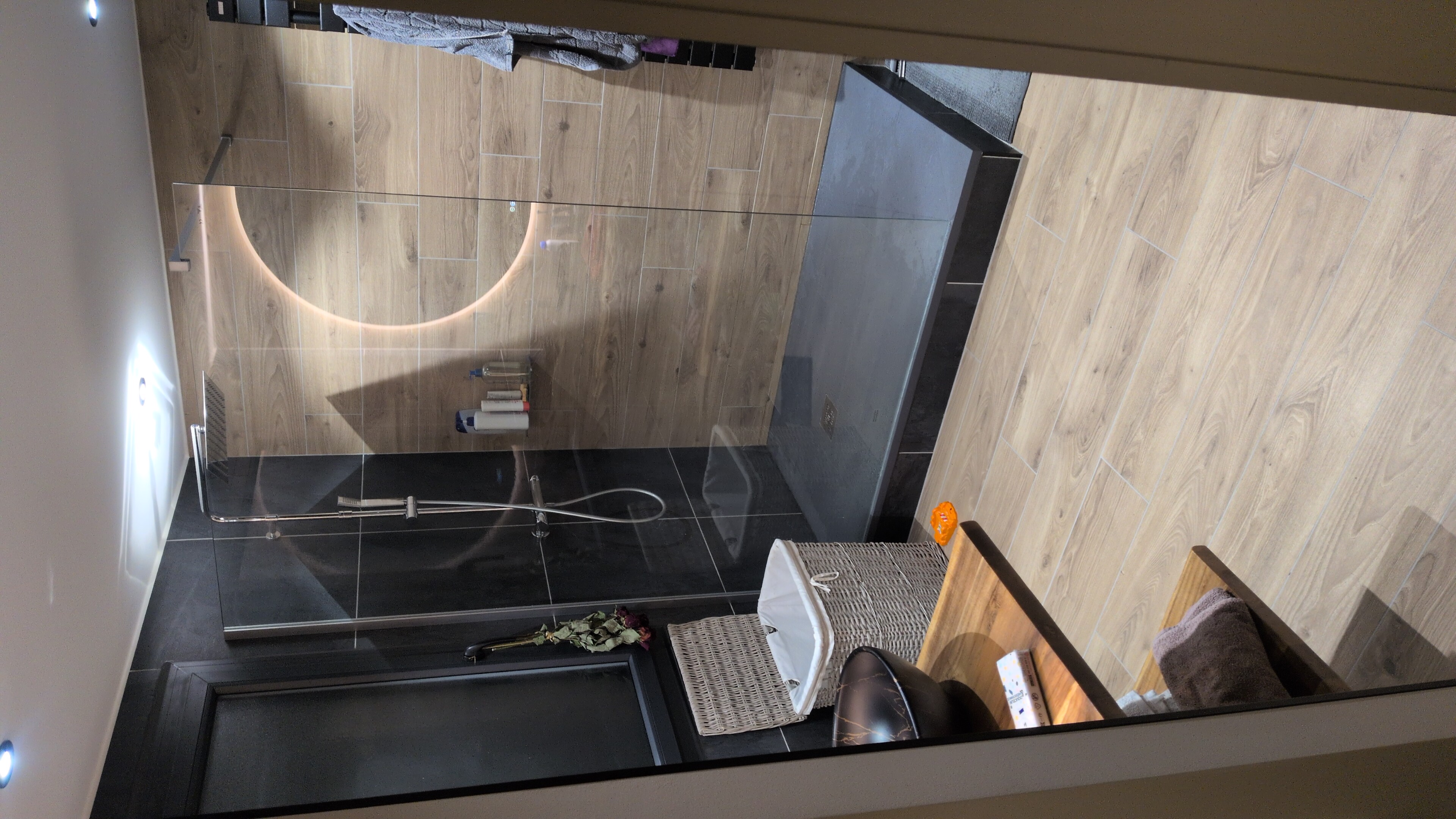 Salle de bain avec douche et miroir rétroéclairé